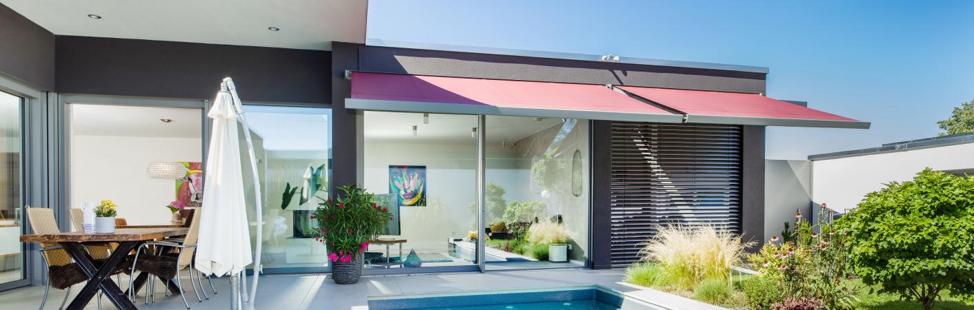 Fenster mit Hebeschiebetür zur Terrasse mit Pool im Vordergrund